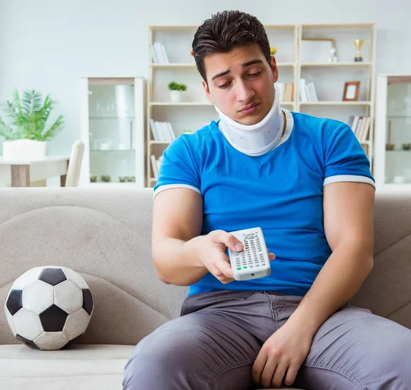 Hombre con lesión en el cuello viendo fútbol fútbol en casa —  Fotos de Stock