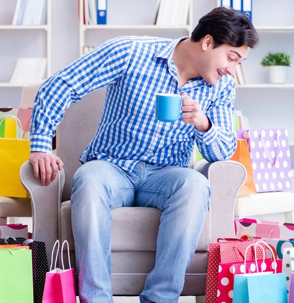 Ung man efter överdriven shopping hemma — Stockfoto