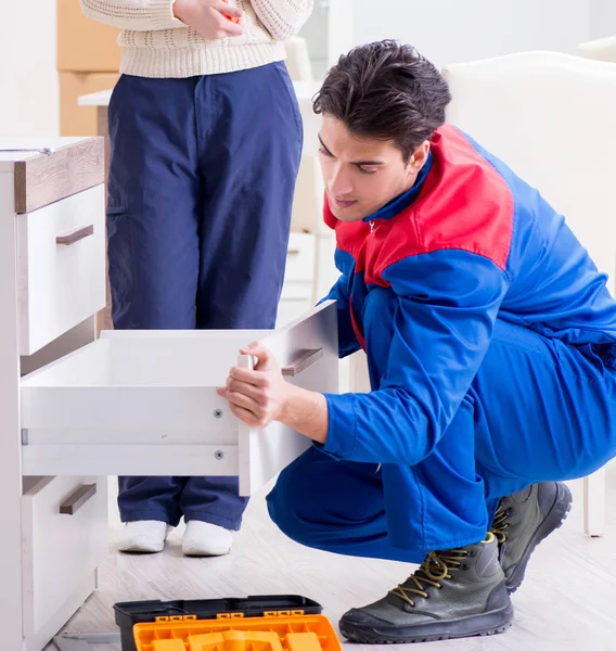 Bauunternehmer repariert Möbel unter weiblicher Aufsicht — Stockfoto