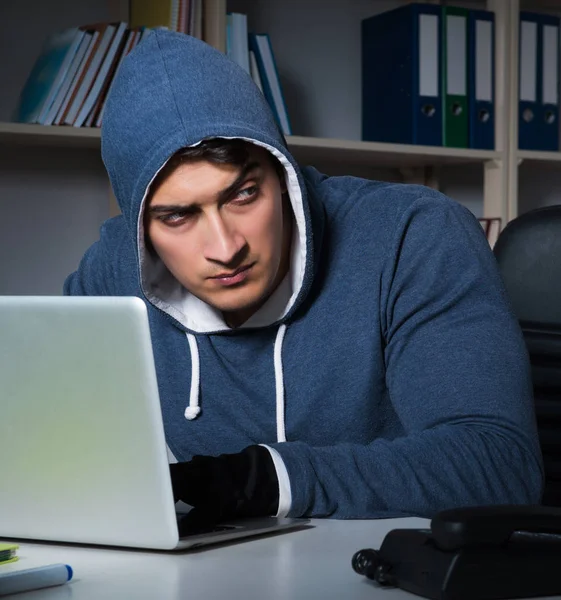 Молодой хакер взламывает компьютеры ночью — стоковое фото