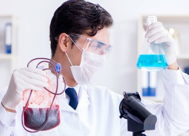 Hastane kliniğinde kan örnekleriyle çalışan bir doktor.