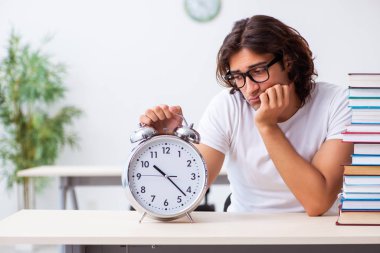 Sınıfta oturan genç erkek öğrenci.