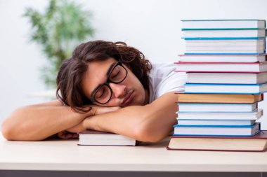 Sınıfta oturan genç erkek öğrenci.