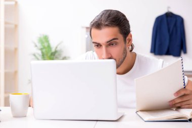 Evde sınava hazırlanan genç bir erkek öğrenci.