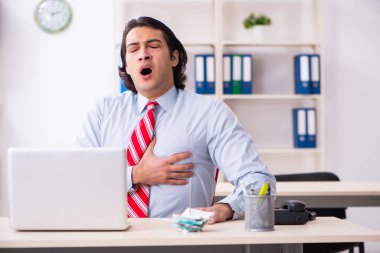 Ofiste acı çeken genç bir erkek işçi.