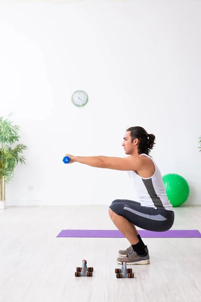 Joven hombre guapo haciendo ejercicios deportivos en el interior — Foto de Stock