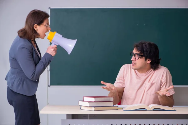 Gammal kvinnlig lärare och manlig student i klassrummet — Stockfoto