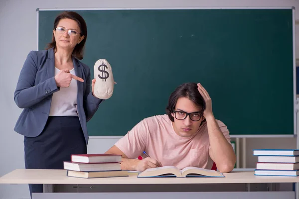 Gammal kvinnlig lärare och manlig student i klassrummet — Stockfoto