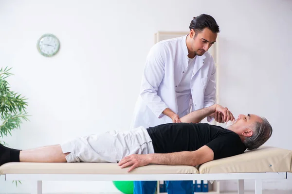 Viejo hombre herido visitando joven médico — Foto de Stock