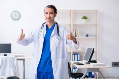 Klinikte çalışan genç erkek doktor.