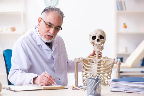 Starzejący się lekarz ze szkieletem — Zdjęcie stockowe