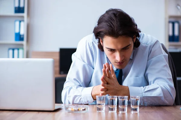 Hombre empleado beber vodka y fumar cigarrillos en el lugar de trabajo — Foto de Stock