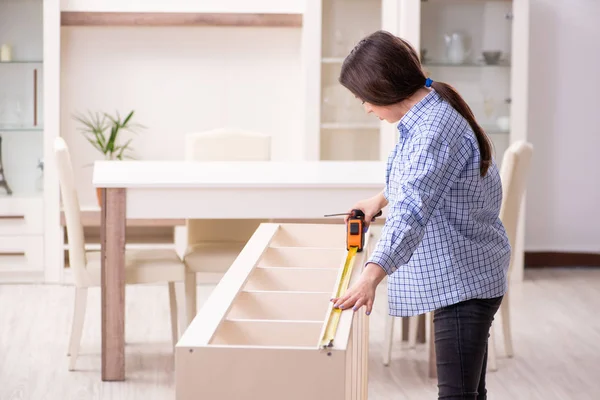 Joven hermosa mujer ensamblando muebles en casa — Foto de Stock