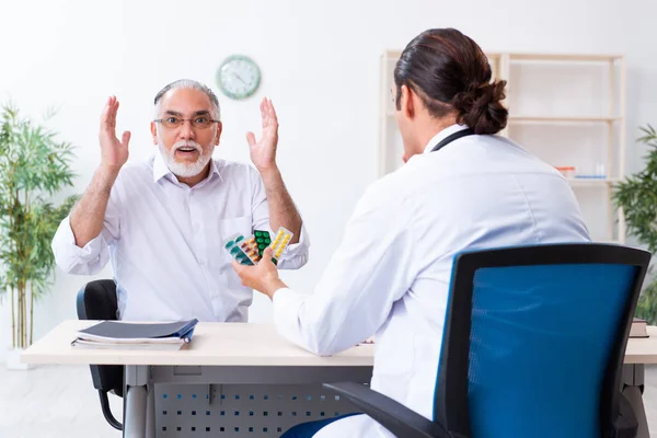 Alt mann besuch jung männlich doktor — Stockfoto