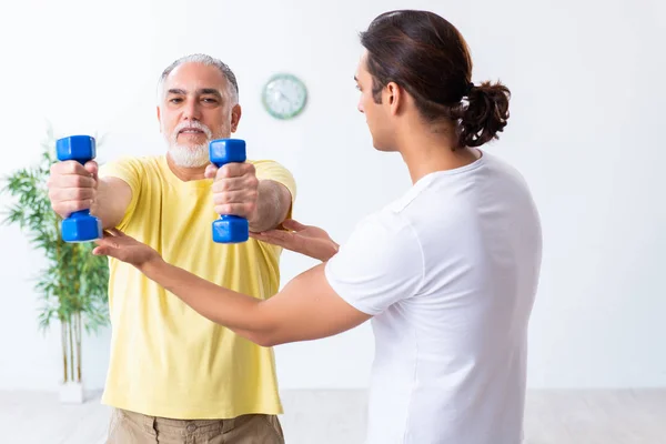 Alter Mann macht Übungen drinnen — Stockfoto