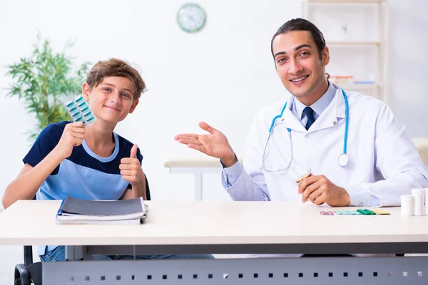 Joven médico examinando a un niño en la clínica —  Fotos de Stock