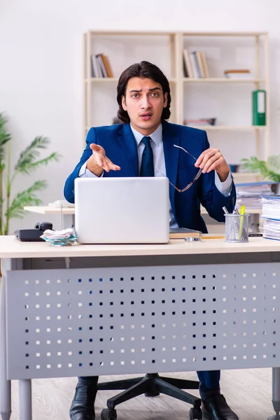Молодой бизнесмен, сидящий и работающий в офисе — стоковое фото