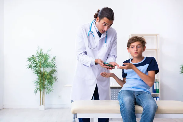 Jeune homme médecin examinant garçon à la clinique — Photo