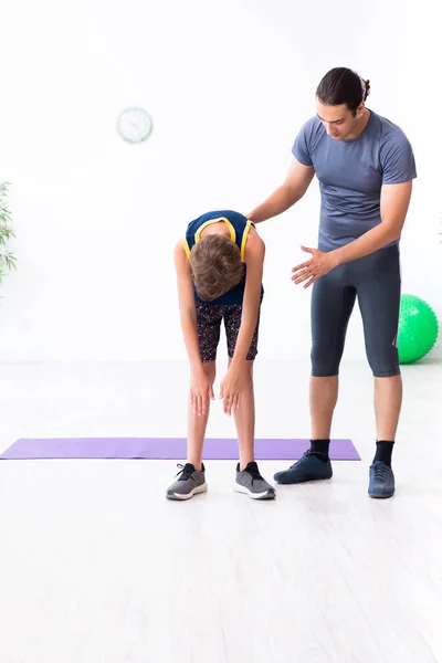 Jovem pai e seu filho fazendo exercícios — Fotografia de Stock