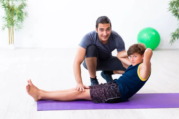 Junger Vater und sein Sohn bei Übungen — Stockfoto