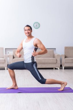 Genç adam evde antrenman ve egzersiz yapıyor.