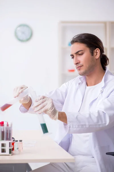 Jonge mannelijke chemicus werkzaam in het lab — Stockfoto