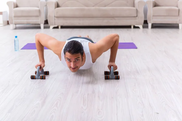 Giovane formazione ed esercizio fisico a casa — Foto Stock