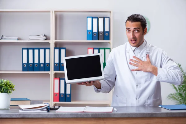 Hastanedeki resepsiyondaki genç erkek doktor. — Stok fotoğraf