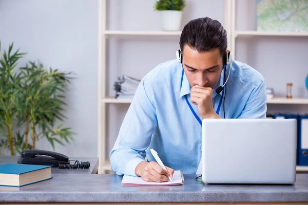 Jonge mannelijke reisagent werkzaam in het kantoor — Stockfoto