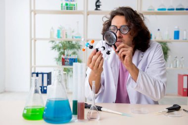 Laboratuvarda çalışan komik erkek kimyager.