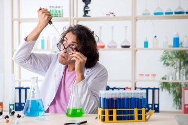 Laboratuvarda çalışan komik erkek kimyager.