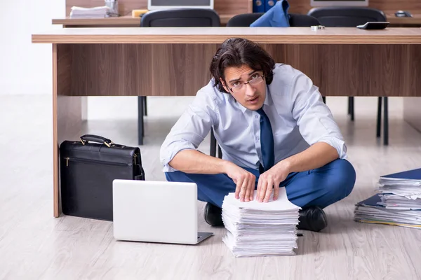 Young male employee and too many work in the office — Stock Photo, Image