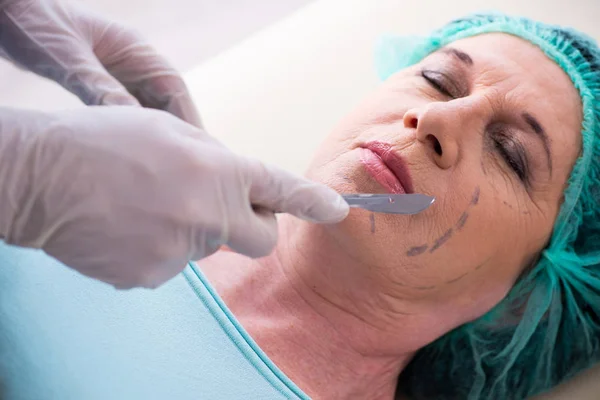 Oude vrouw bezoekt mannelijke arts voor plastische chirurgie — Stockfoto