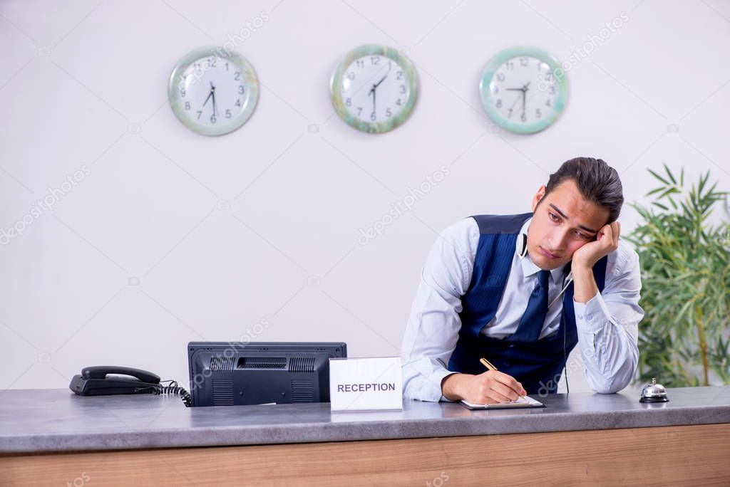 Young man receptionist at the hotel counter