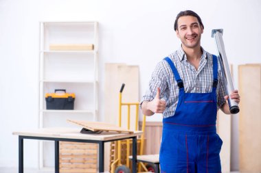 Genç erkek marangoz içeride çalışıyor.