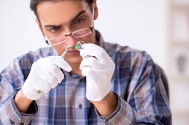 Genç erkek kuyumcu atölyede.