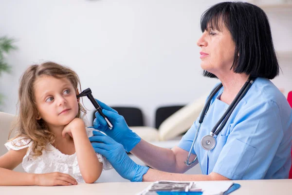 Liten flicka besöker gammal kvinnlig läkare — Stockfoto