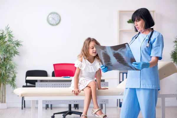 Menina visitando velho médico feminino — Fotografia de Stock