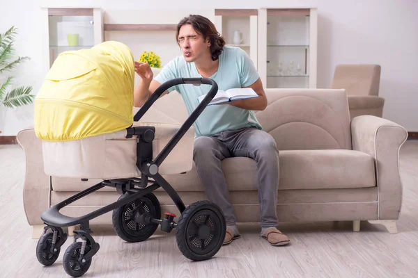 Joven cuidando al bebé en cochecito — Foto de Stock