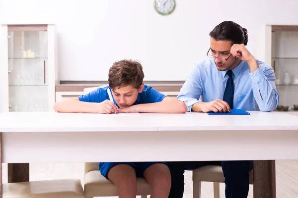 Upptagen far hjälpa sin son att förbereda sig för examen — Stockfoto