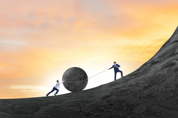 Teamwork example with business people pushing stone to top — Stock Photo, Image