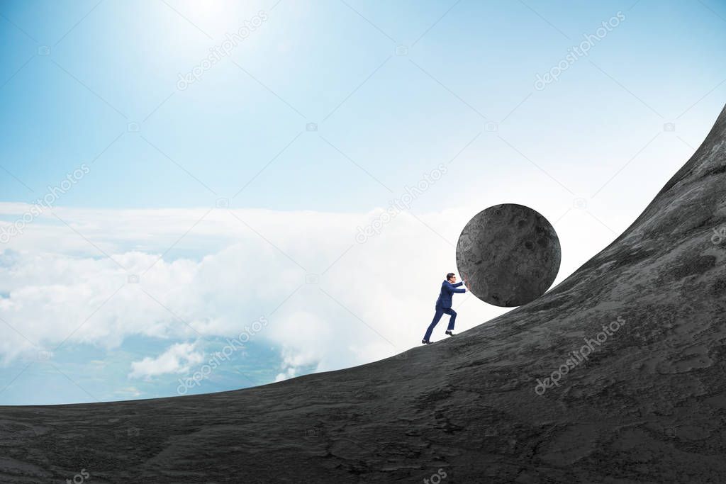 Man pushing large stone to the top