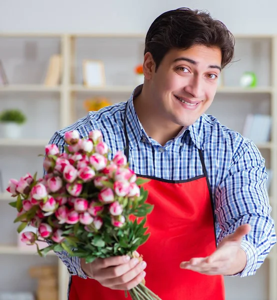 El asistente de la floristería ofreciendo un ramo de flores — Foto de Stock