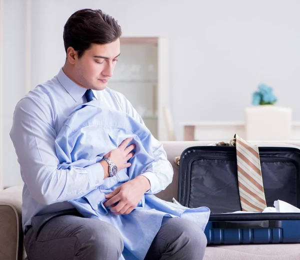 Empresario preparando el embalaje para su viaje de negocios —  Fotos de Stock