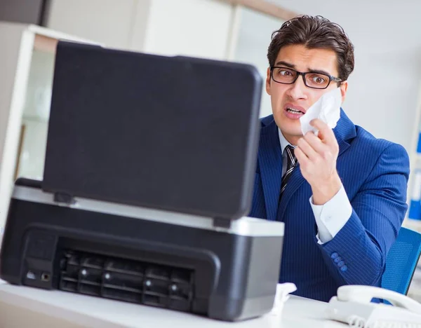 Businessman angry at copying machine jamming papers