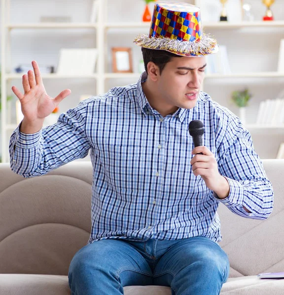 Zabawny człowiek śpiewający piosenki w karaoke w domu — Zdjęcie stockowe