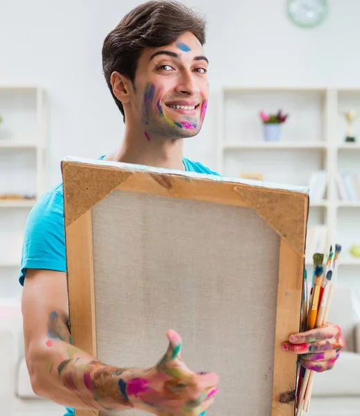 Joven artista divertido trabajando en la nueva pintura en su estudio — Foto de Stock