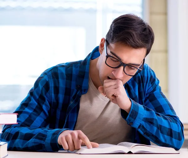 Studente che studia nella biblioteca vuota con libro di preparazione per ex — Foto Stock