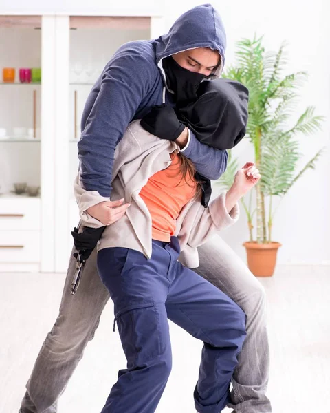 El hombre armado agrediendo a una joven en casa — Foto de Stock