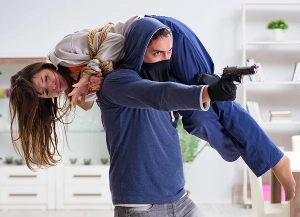 The armed man assaulting young woman at home — Stock Photo, Image